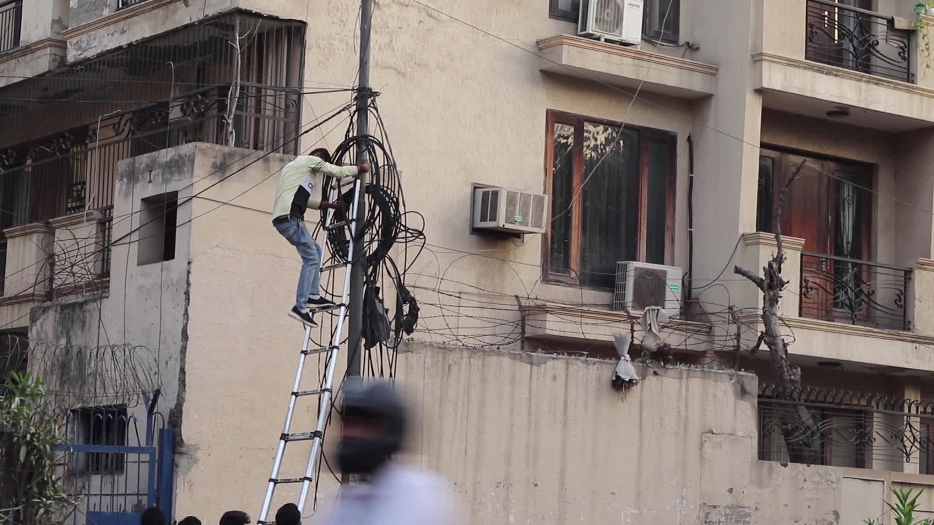 Man getting down from cable poll