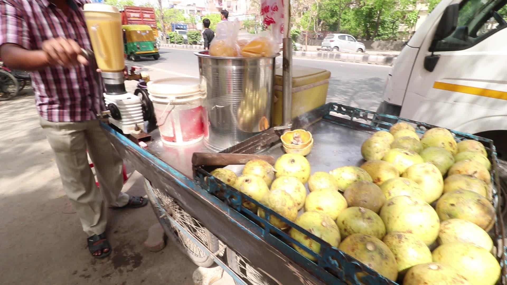 A juice maker preparing summer drink by the road side in New Delhi