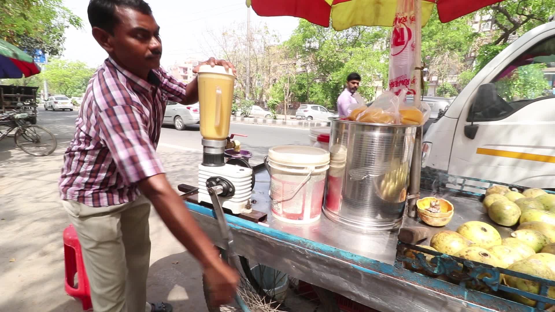 A juice maker preparing summer drink by the road side in New Delhi
