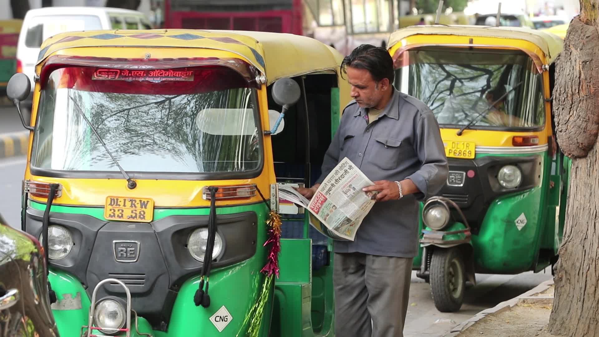 Auto rickshaw driver reads daily hindi newspaper 