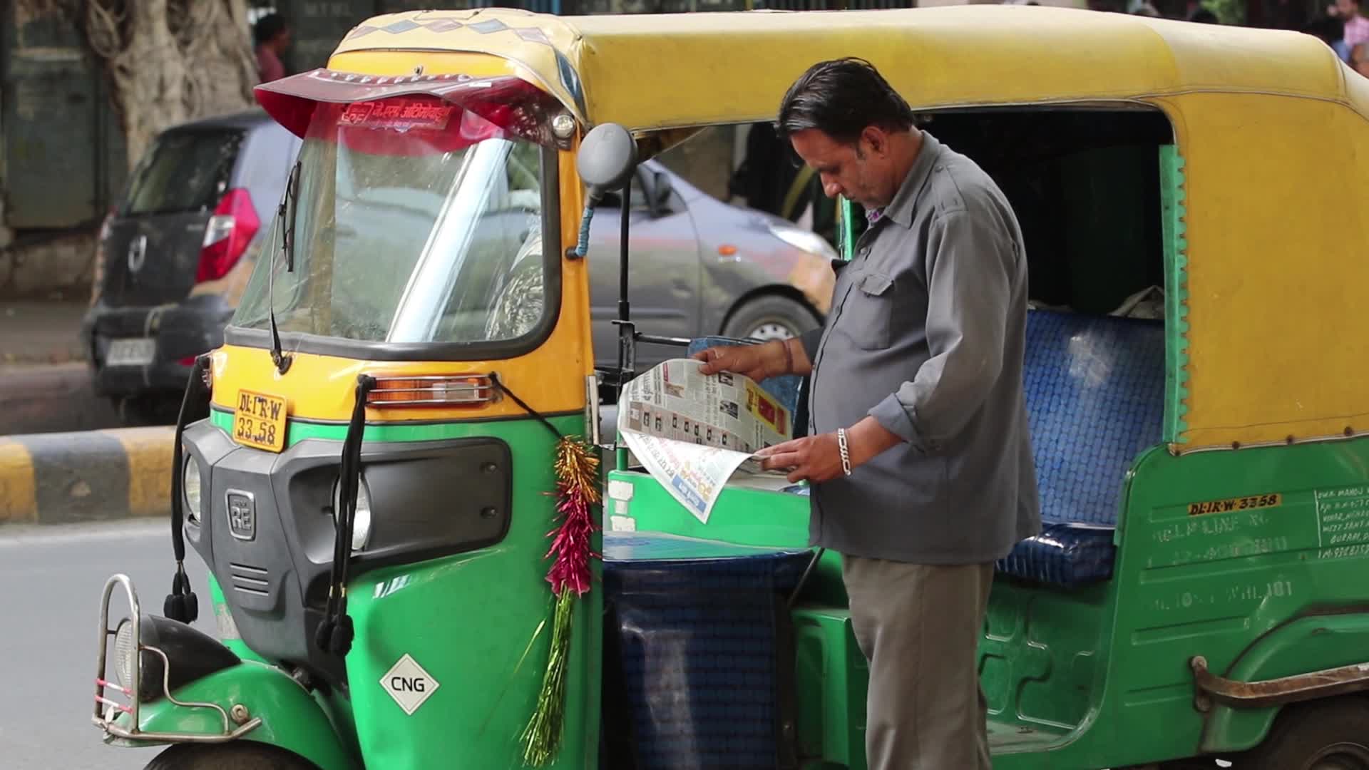 Auto rickshaw driver reads daily hindi newspaper 