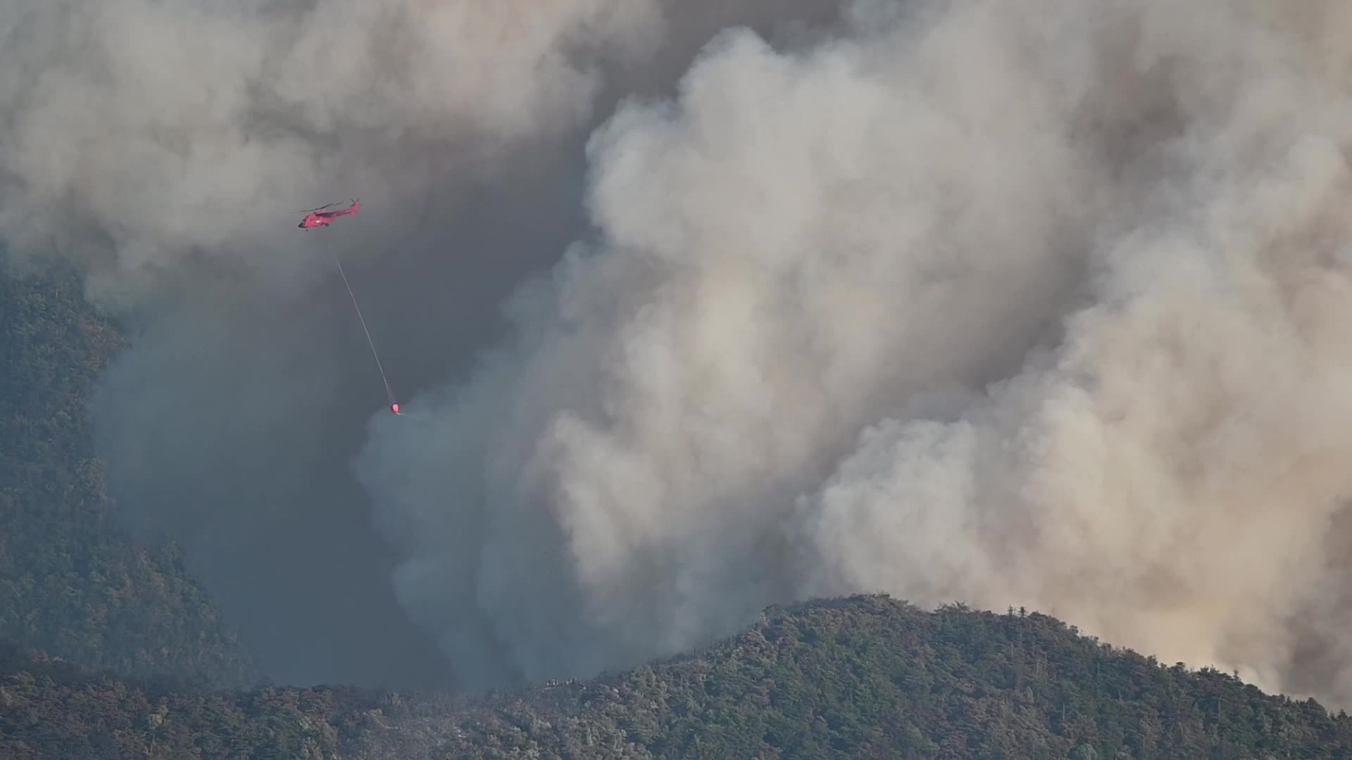 A water bombing helicopter in operation on a major forest fire in the commune of Romeyer