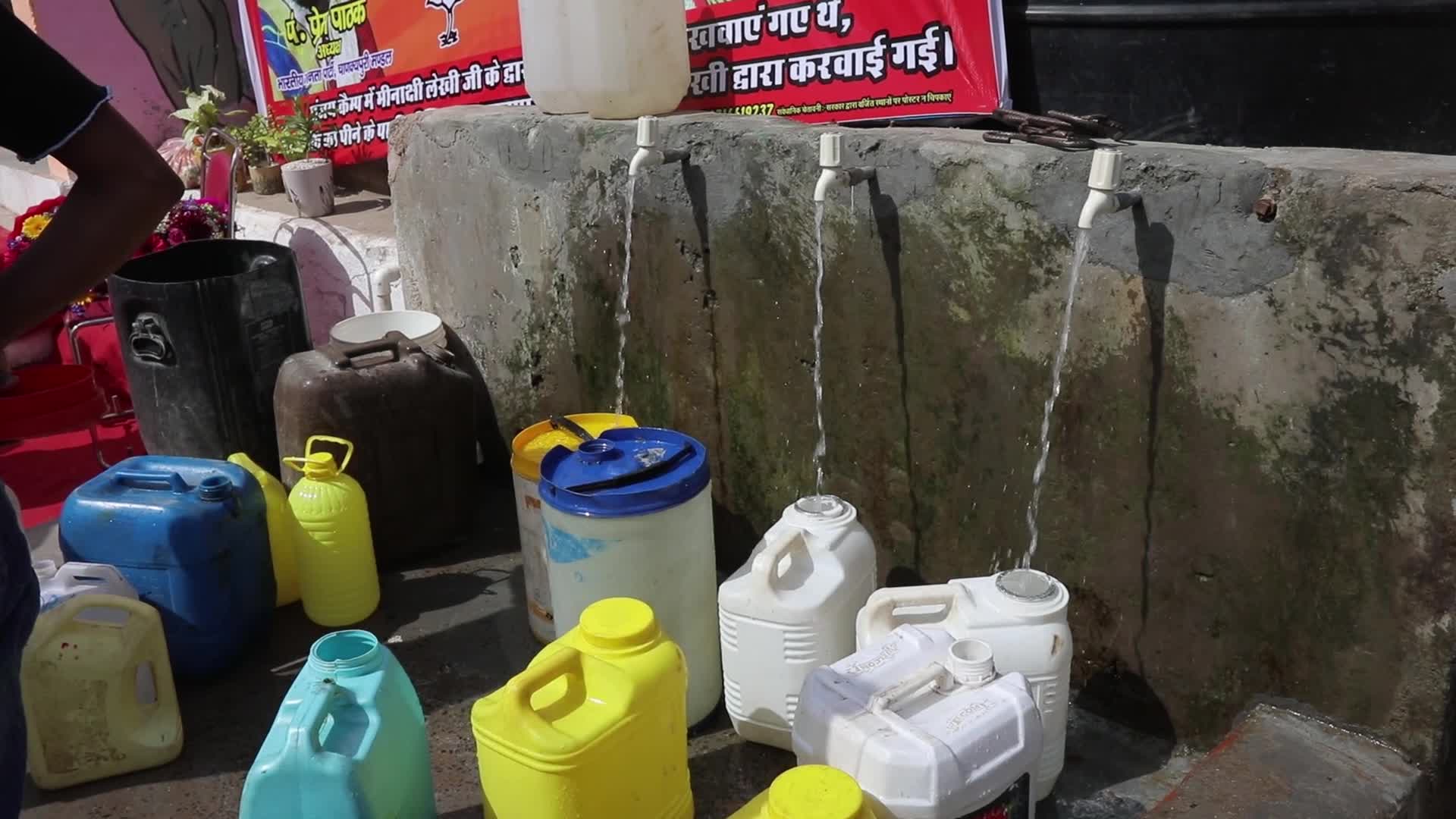 Local residents fill their containers in New Delhi
