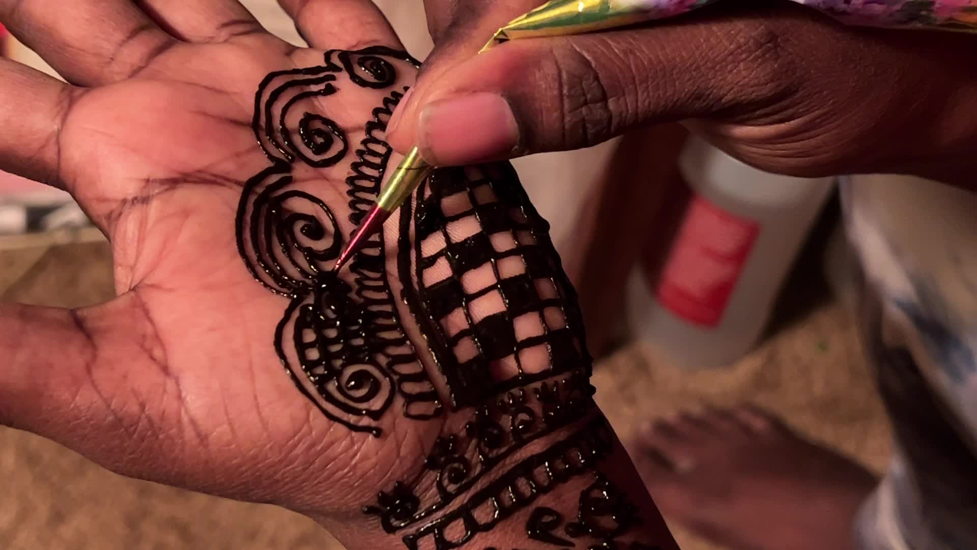 Henna is applied to the hands of a Hindu woman during Diwali