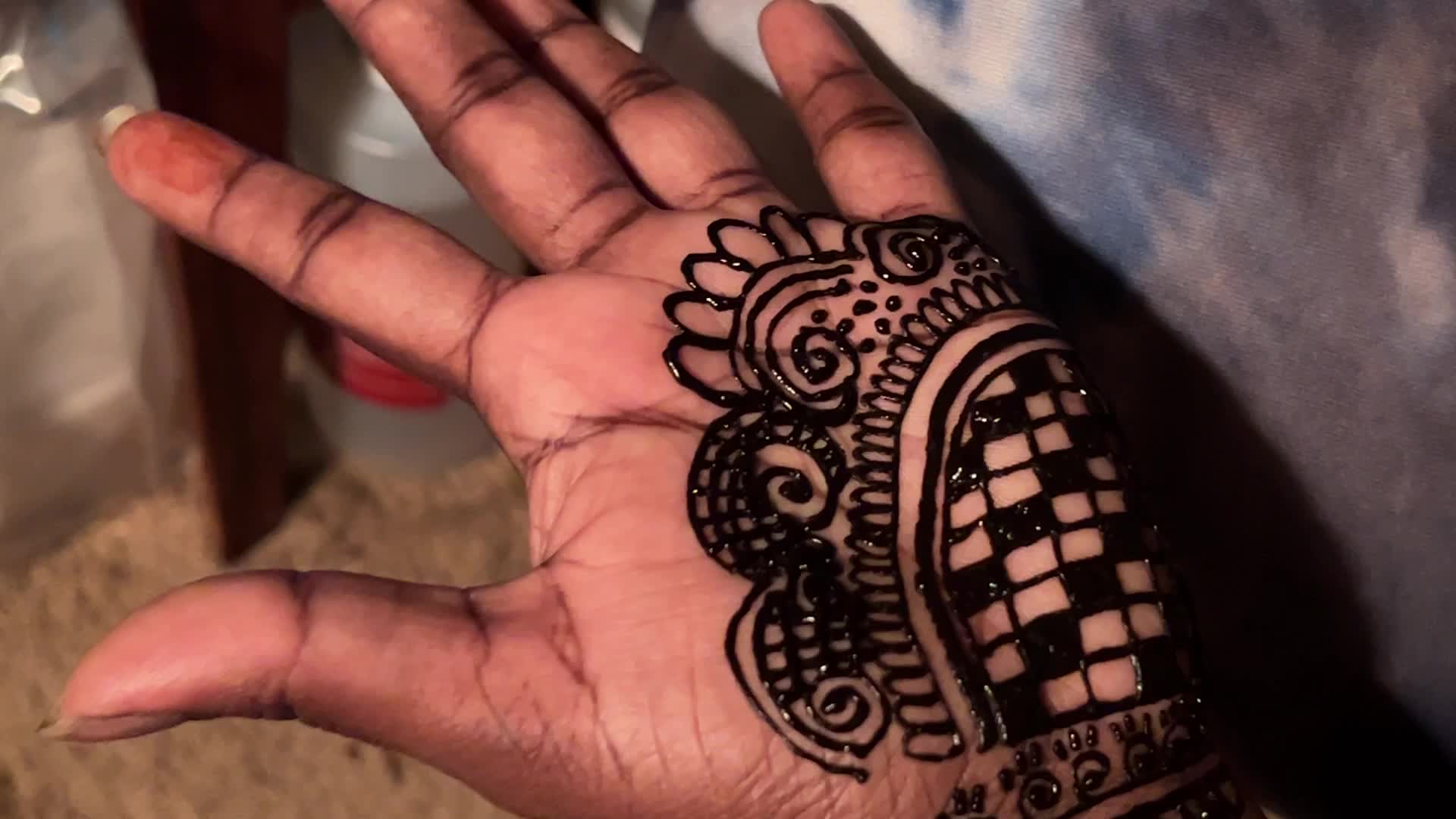 Henna is applied to the hands of a Hindu woman during Diwali