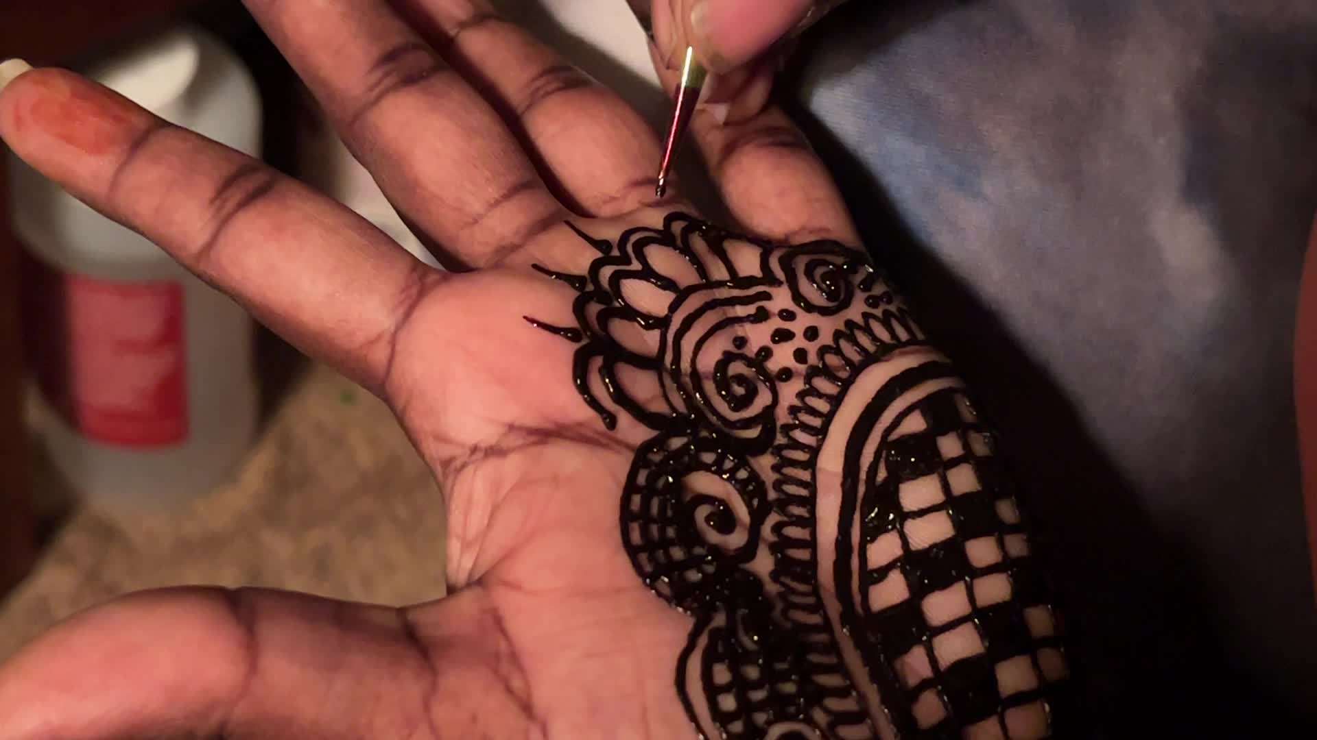 Henna is applied to the hands of a Hindu woman during Diwali