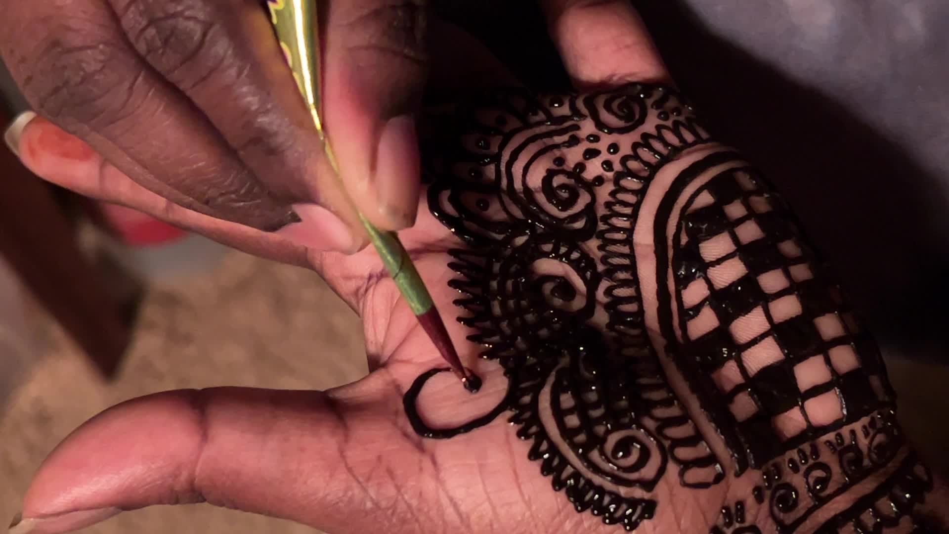 Henna is applied to the hands of a Hindu woman during Diwali