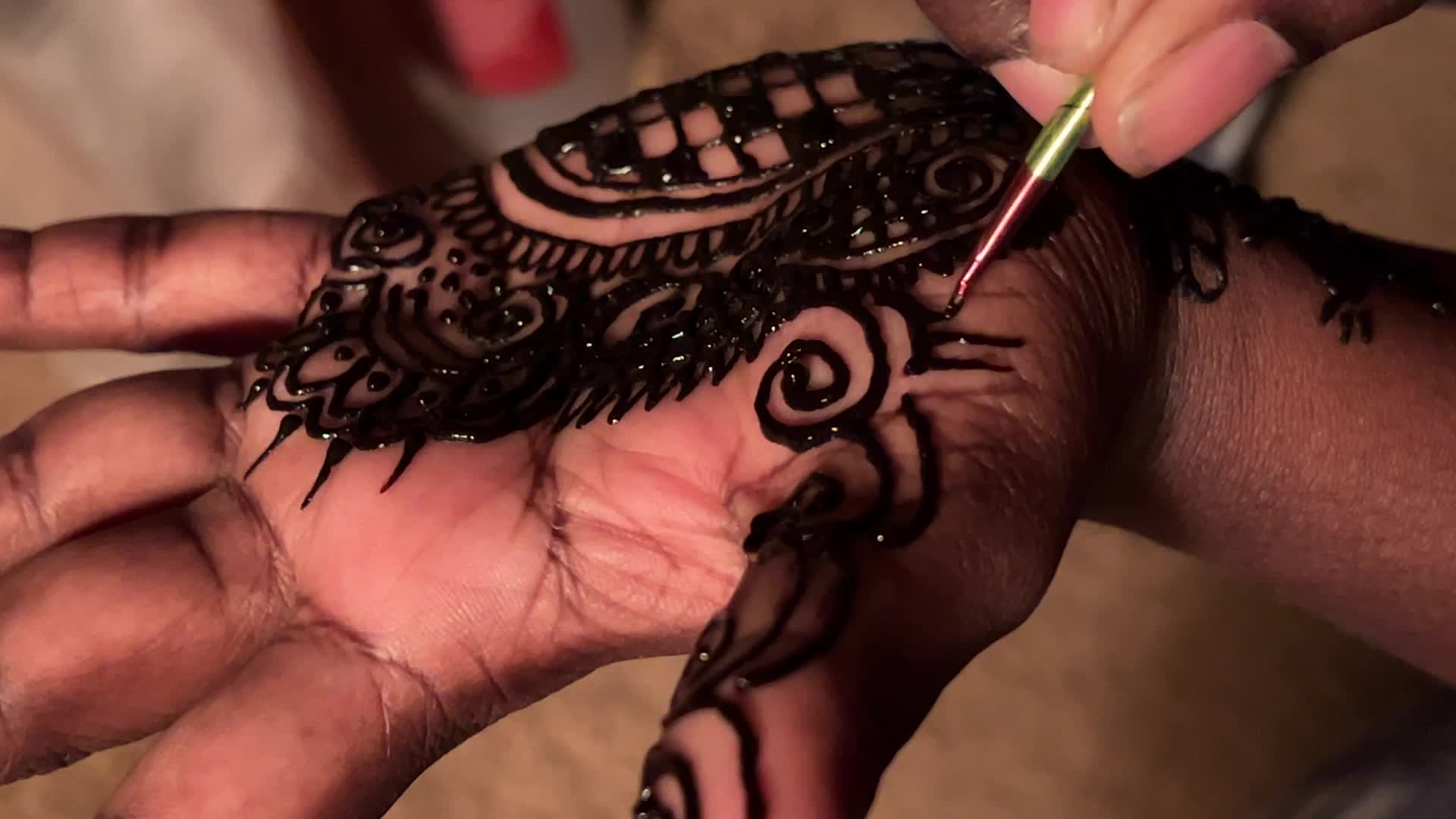 Henna is applied to the hands of a Hindu woman during Diwali