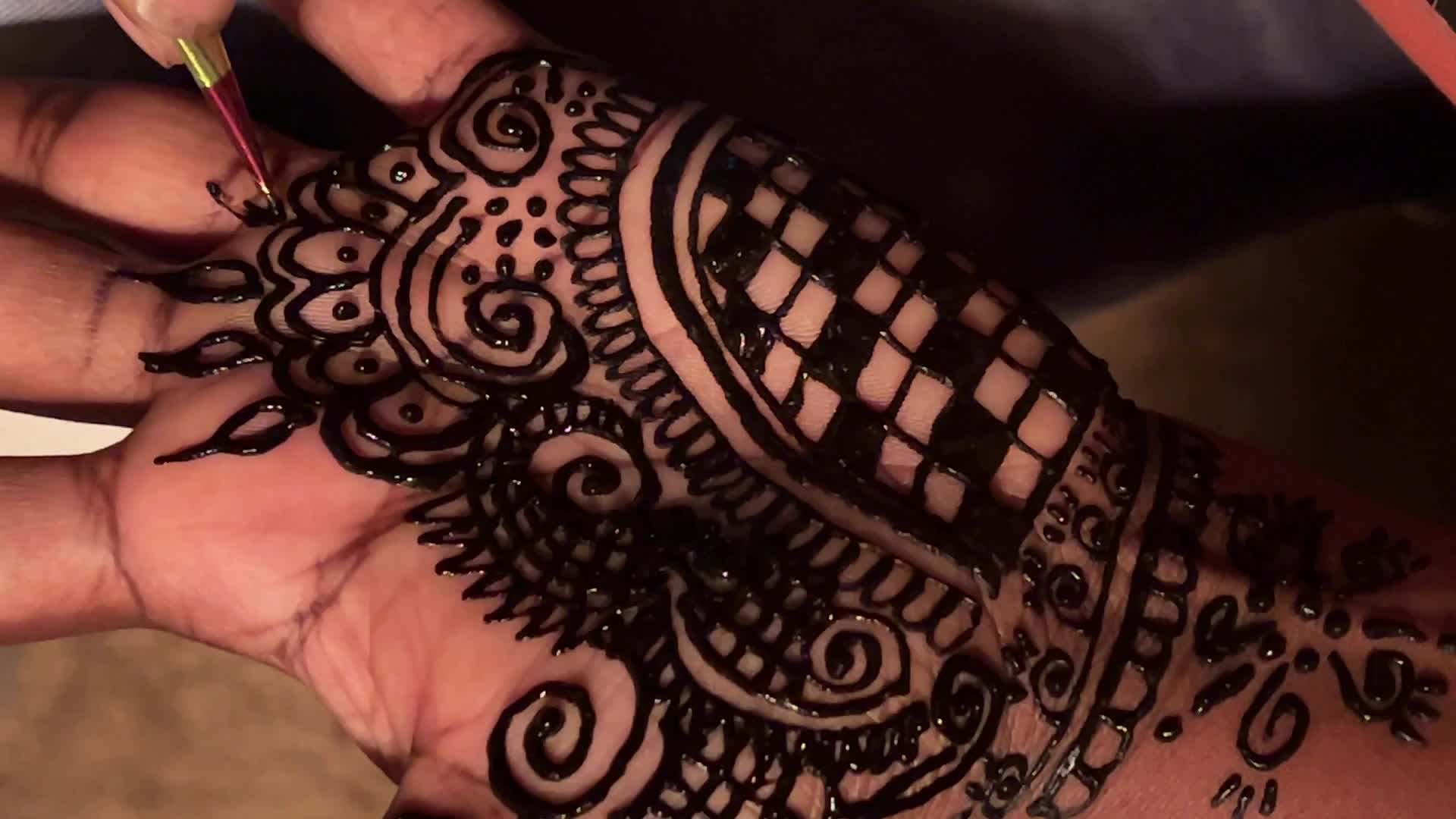 Henna is applied to the hands of a Hindu woman during Diwali