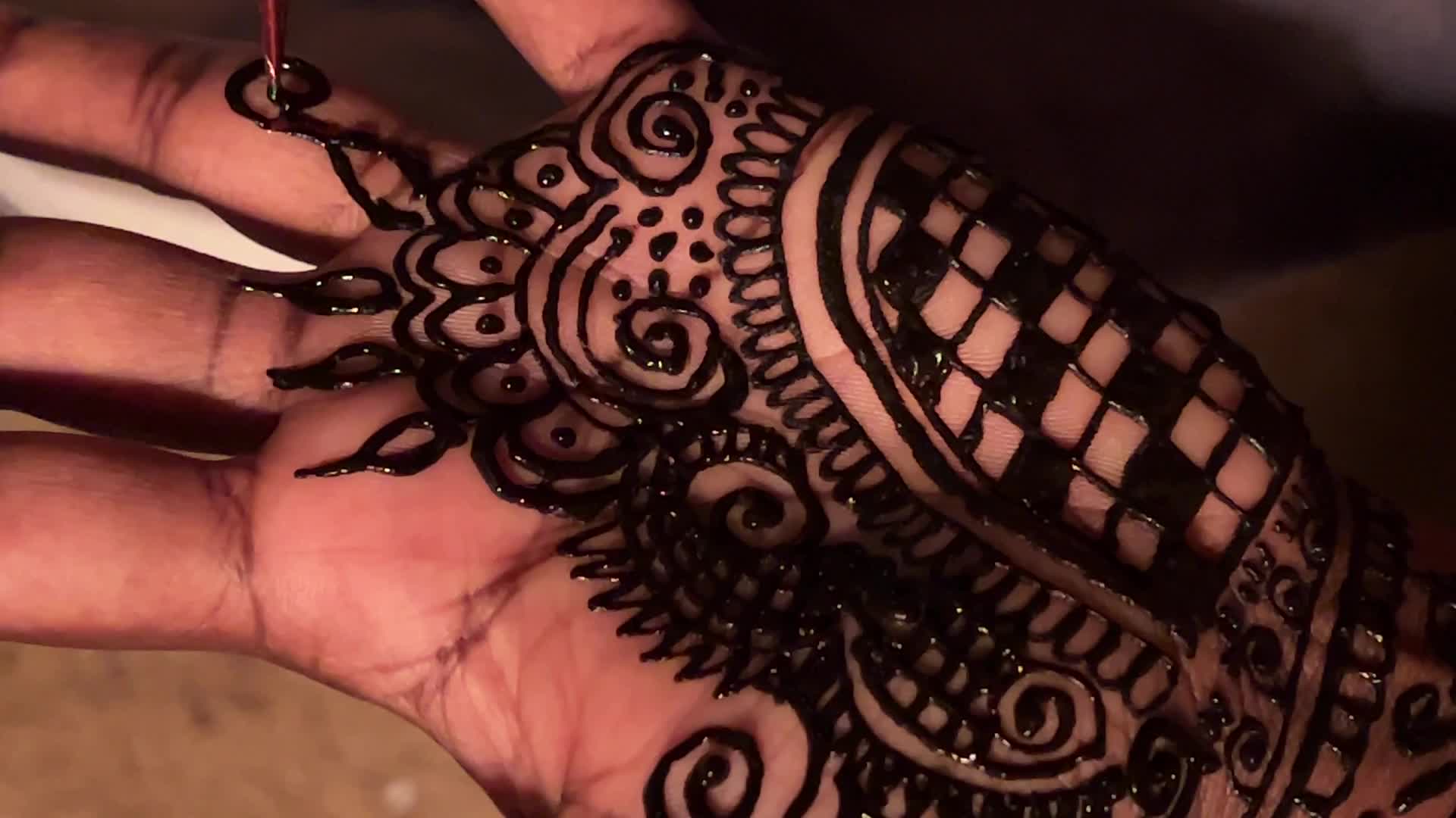 Henna is applied to the hands of a Hindu woman during Diwali