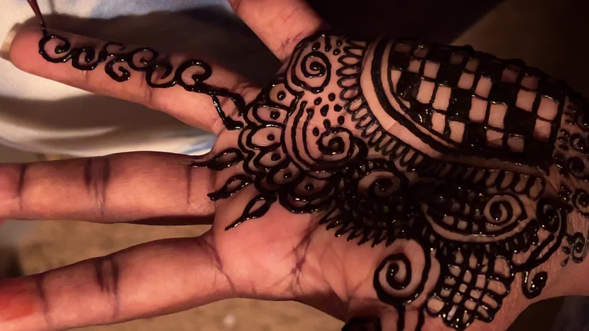 Henna is applied to the hands of a Hindu woman during Diwali