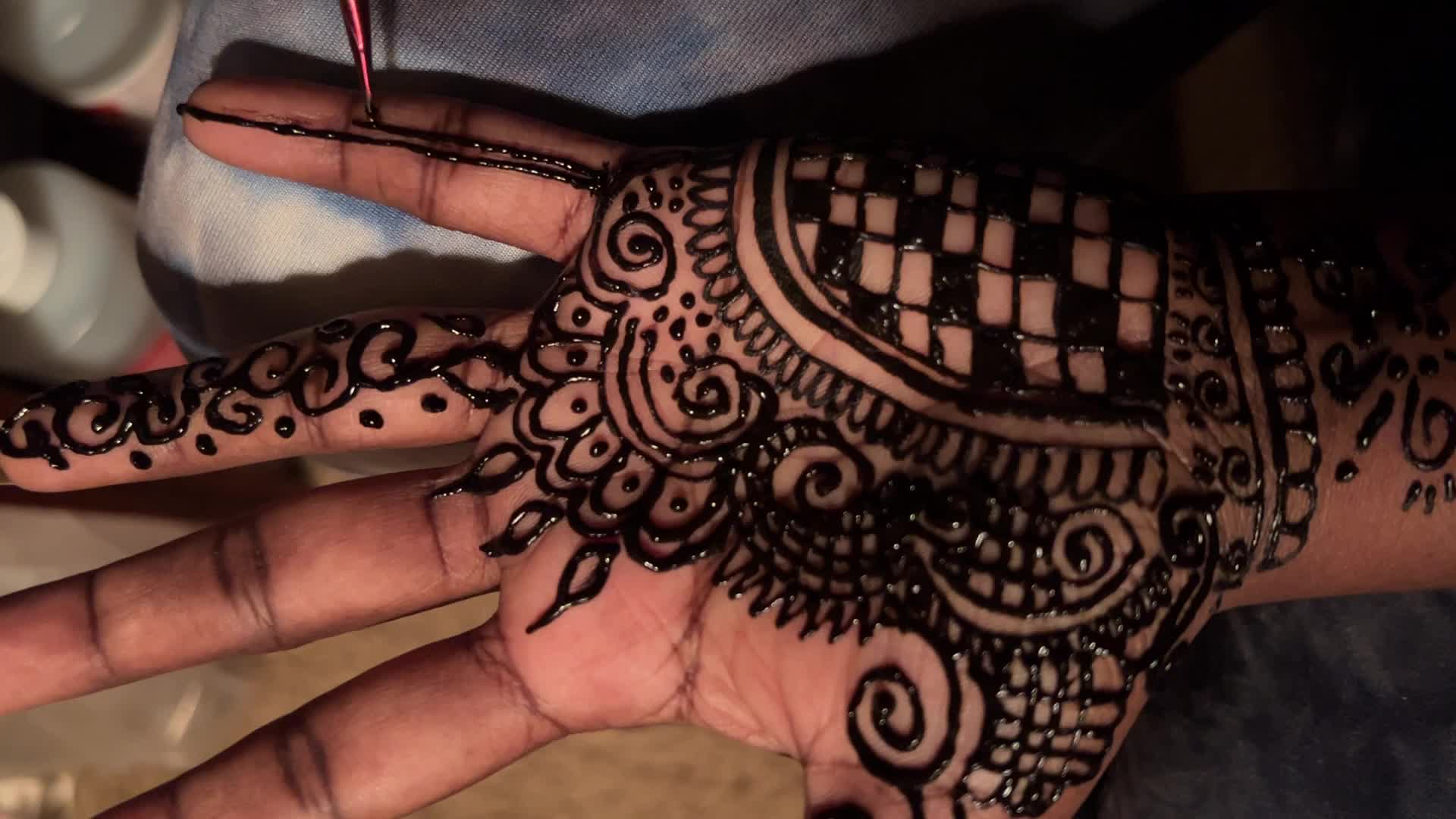 Henna is applied to the hands of a Hindu woman during Diwali
