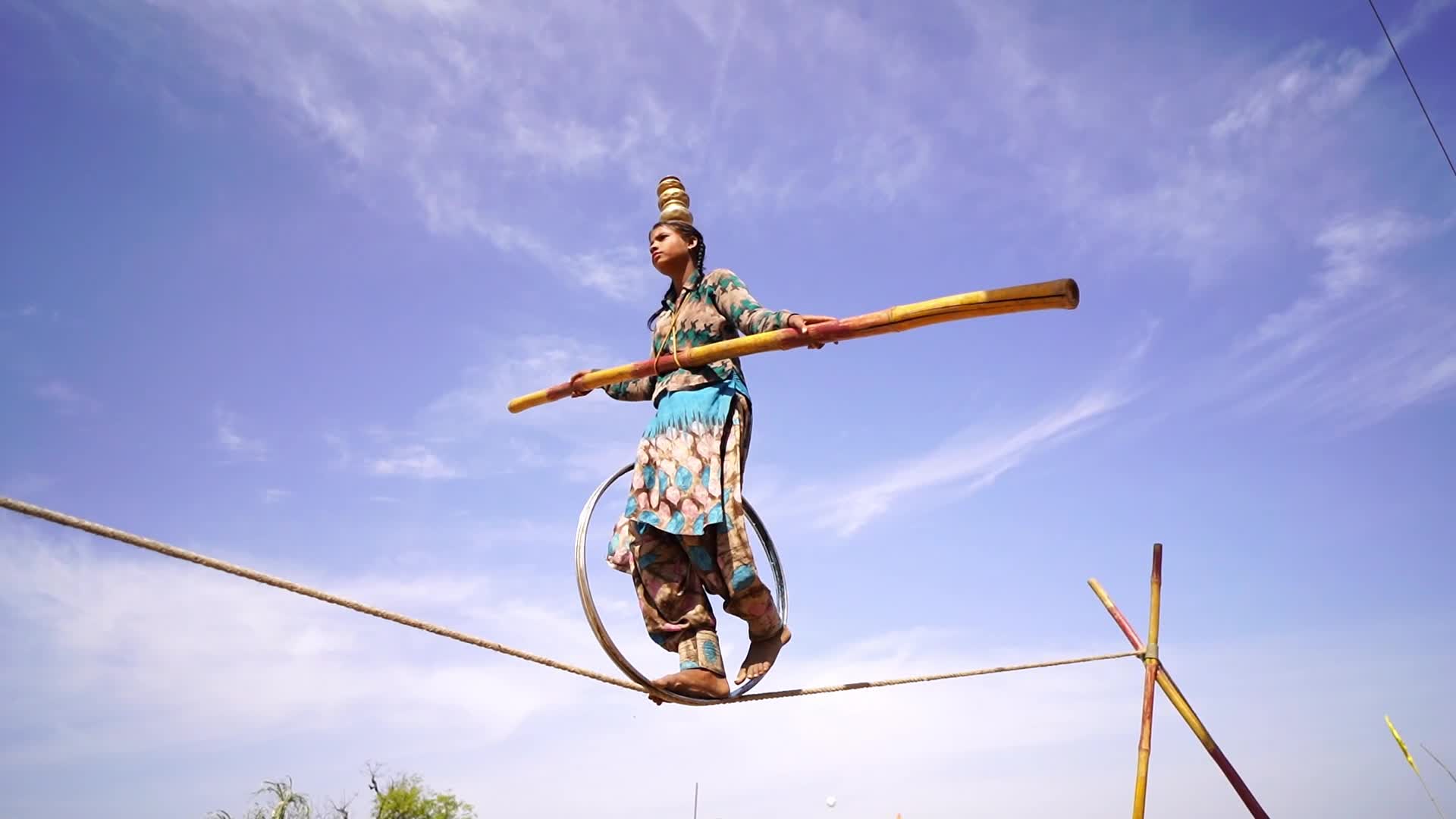 Indian Girl Undertakes a balancing act on a rope during a street show in Pushkar, India