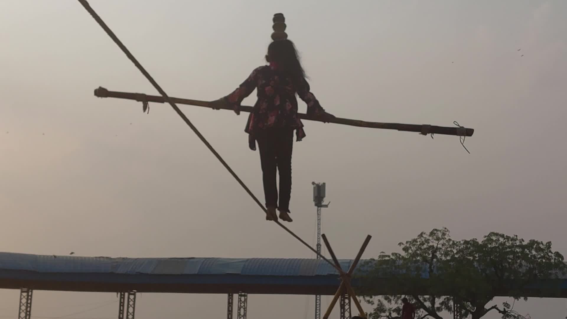 Indian Girl Undertakes a balancing act on a rope during a street show in Pushkar