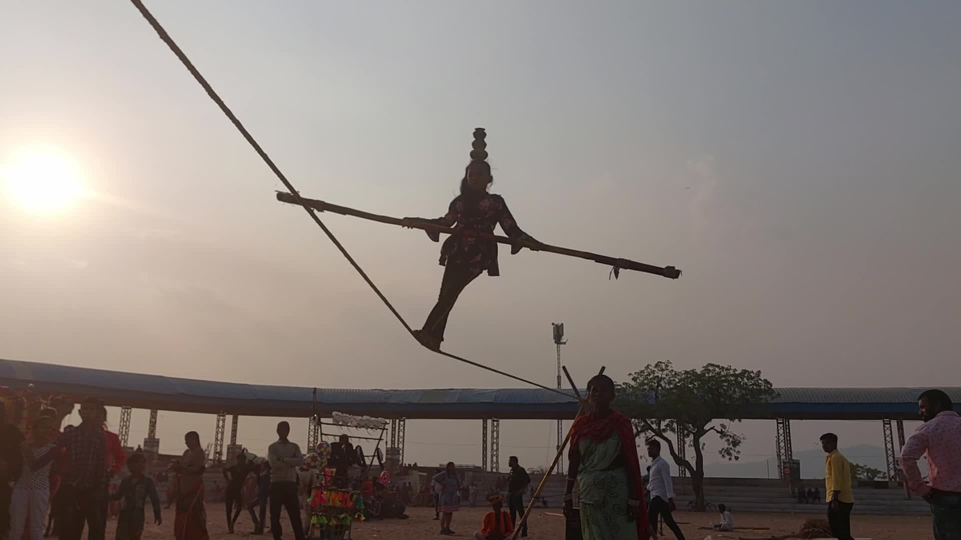 Indian Girl Undertakes a balancing act on a rope during a street show in Pushkar