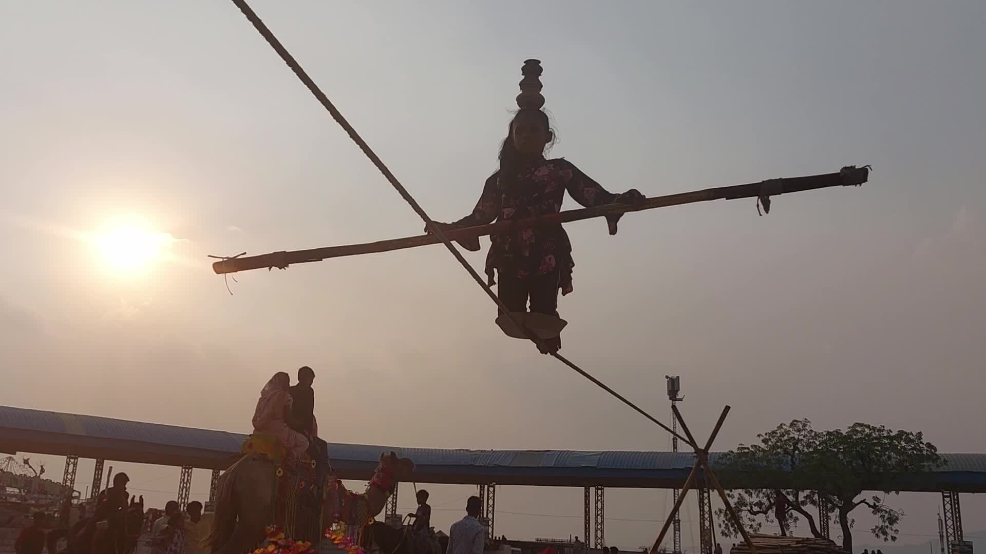 Indian Girl Undertakes a balancing act on a rope during a street show in Pushkar