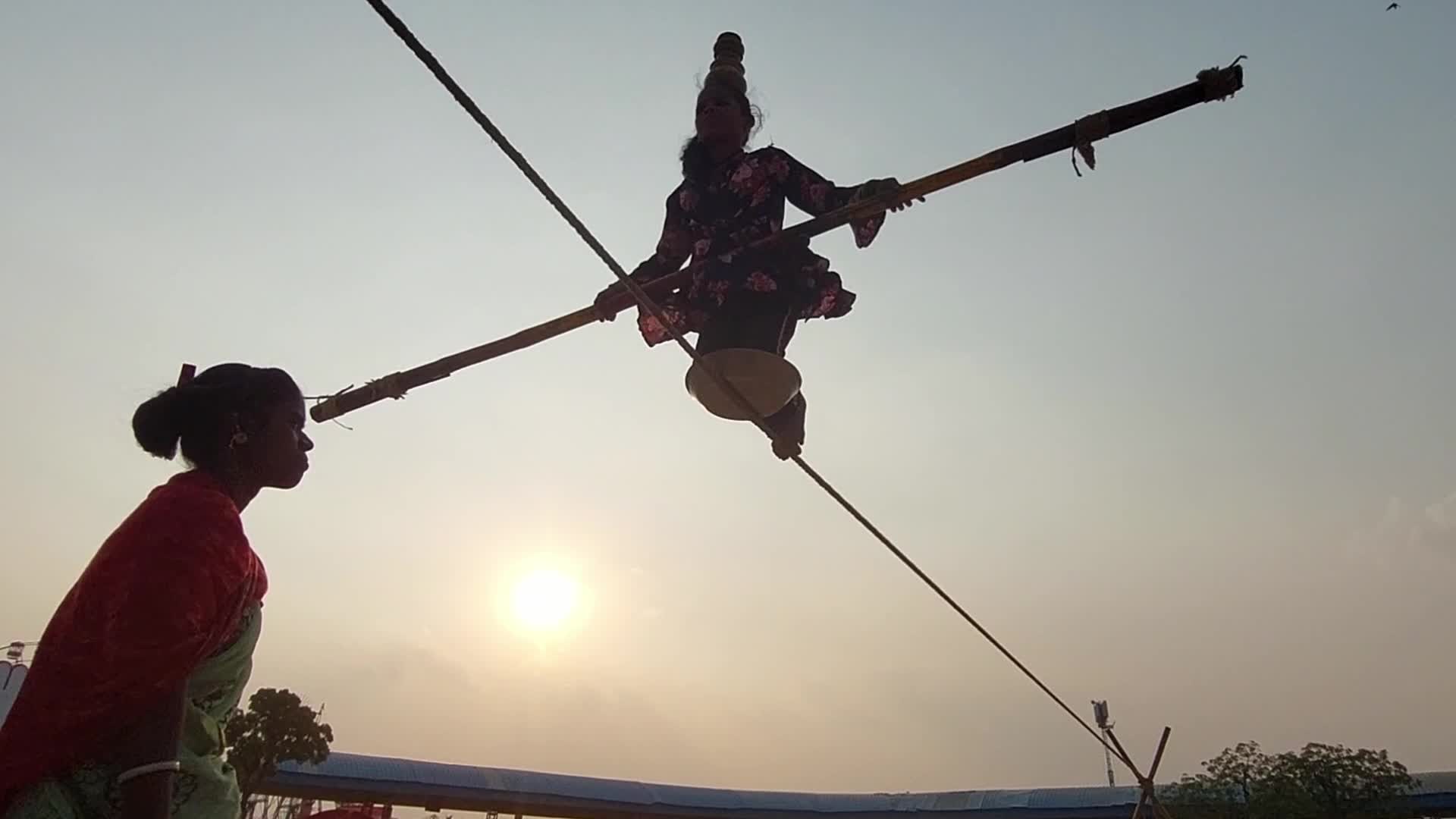 Indian Girl Undertakes a balancing act on a rope during a street show in Pushkar