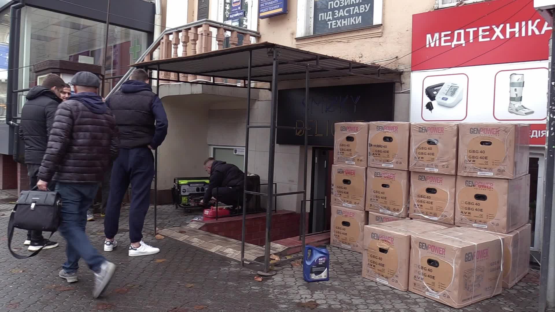 Ukrainians install a electricity generator outside the entrance to a store during emergency power blackout in Odesa