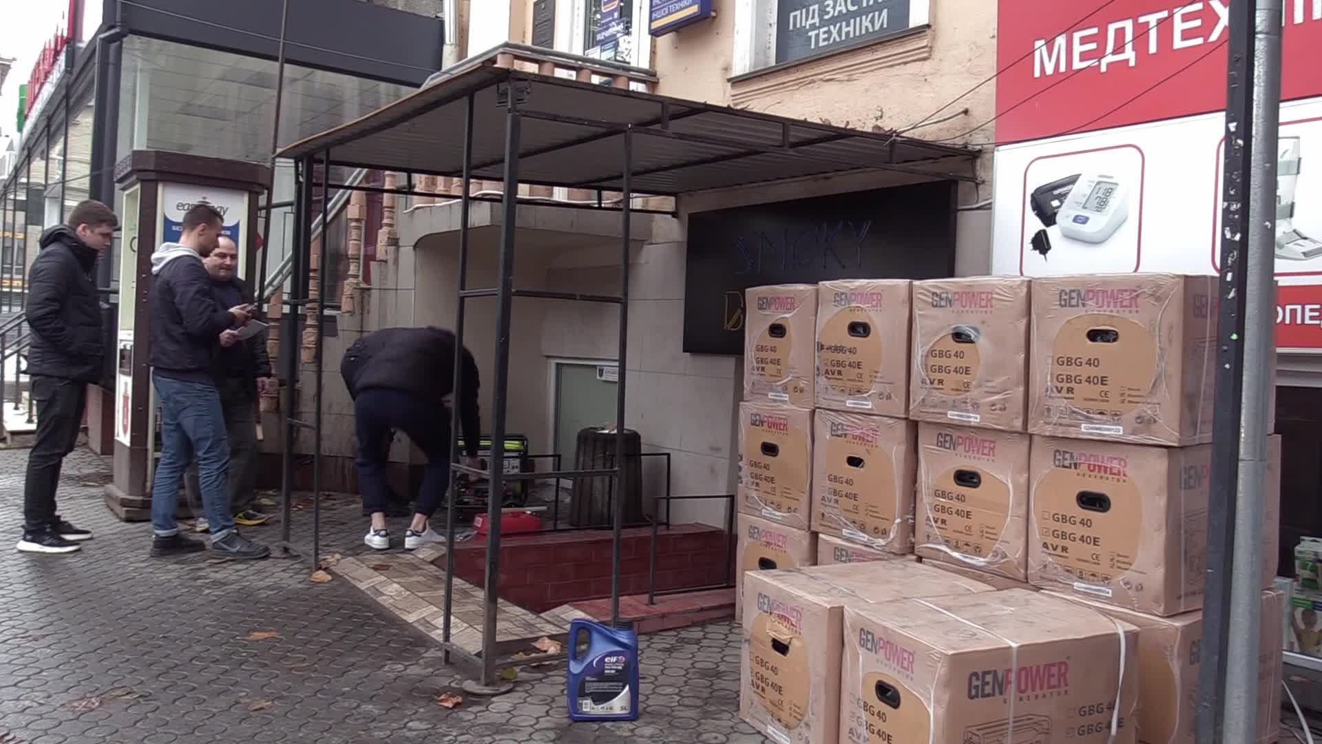 Ukrainians install a electricity generator outside the entrance to a store during emergency power blackout in Odesa