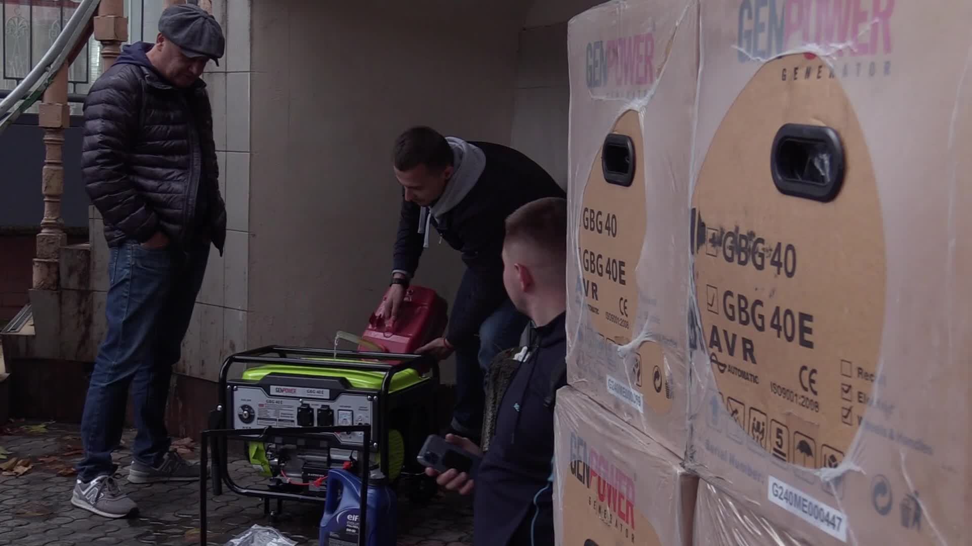 Ukrainians install a electricity generator outside the entrance to a store during emergency power blackout in Odesa