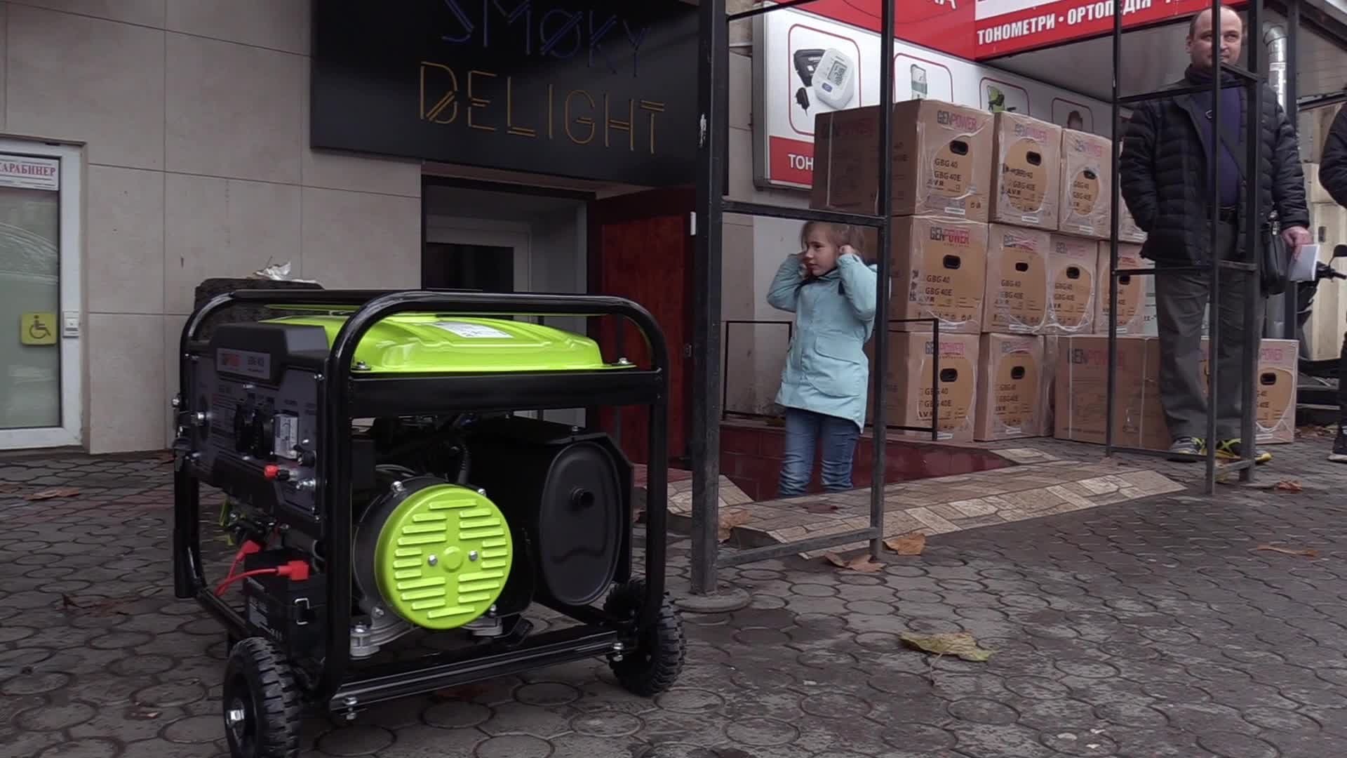 Ukrainians install a electricity generator outside the entrance to a store during emergency power blackout in Odesa