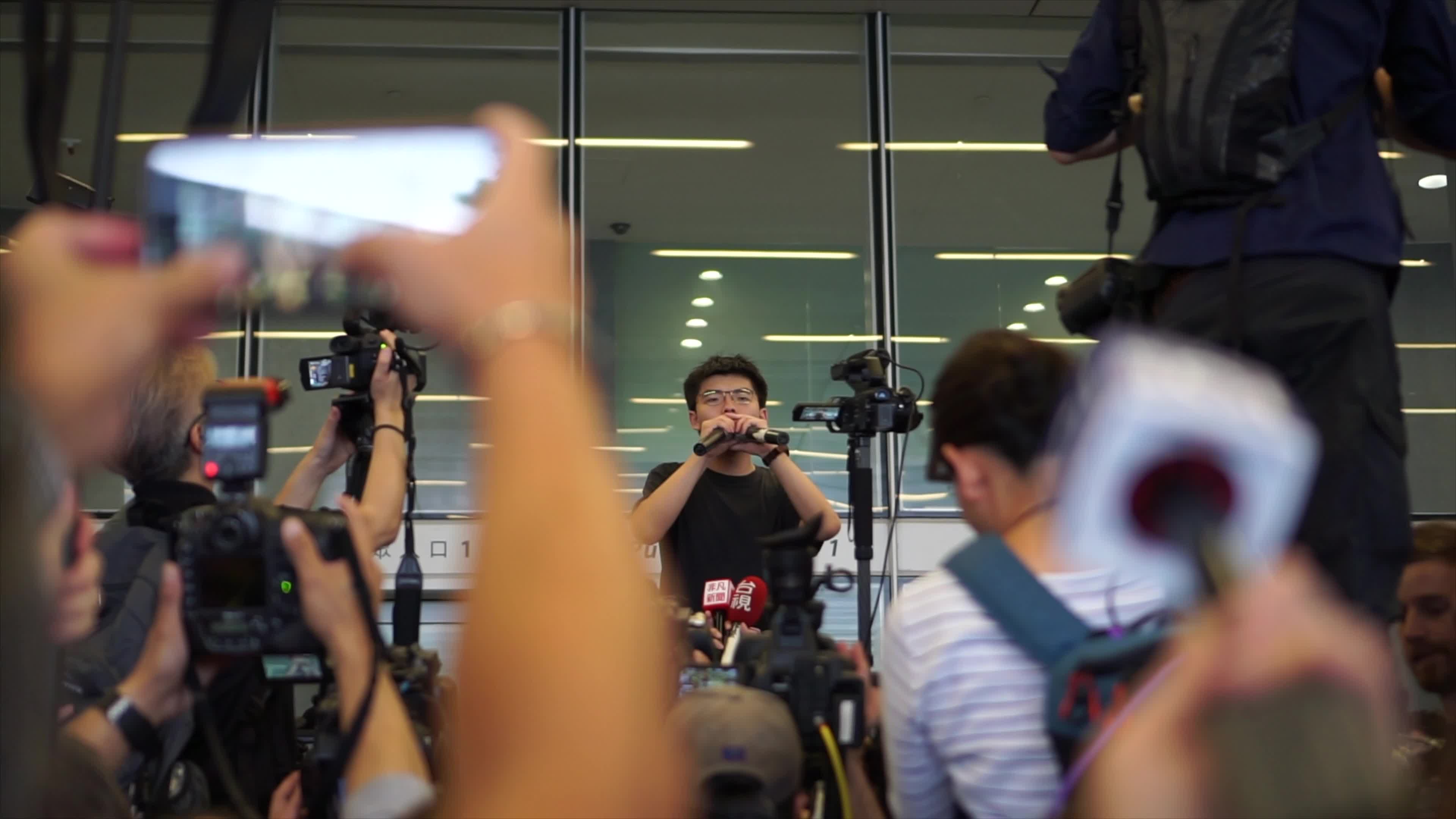 Hong Kong protesters get excited in front of Legislative Council as activist Joshua Wong appears.