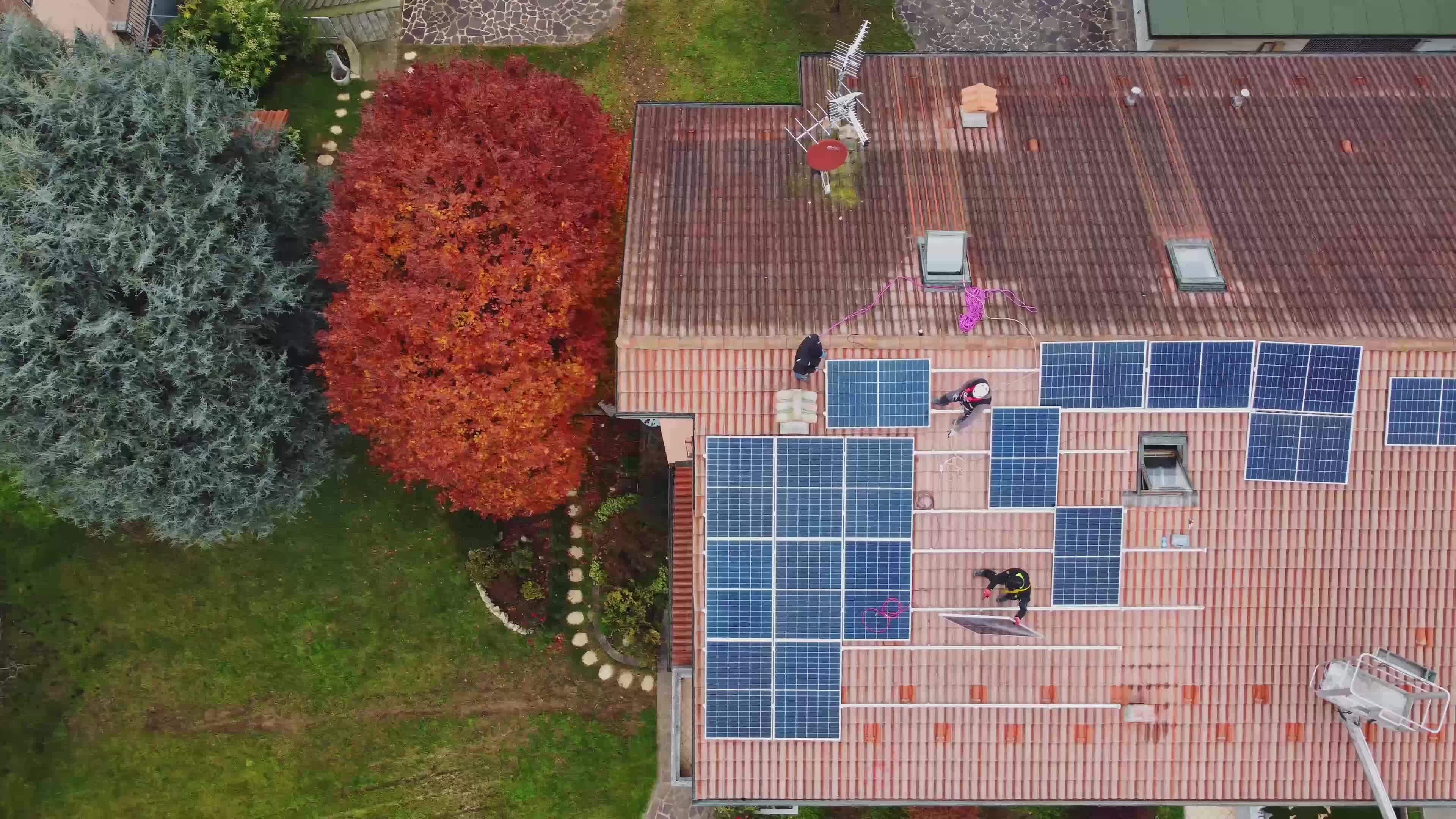 Solar technicians installing solar panels on residential roof