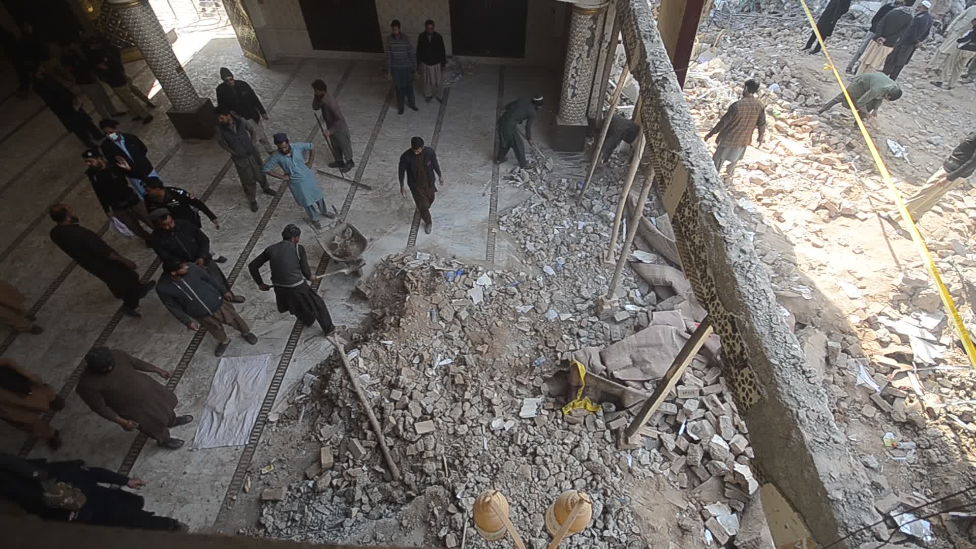 Police secure area of suicide bomb blast at a mosque that killed 100 people