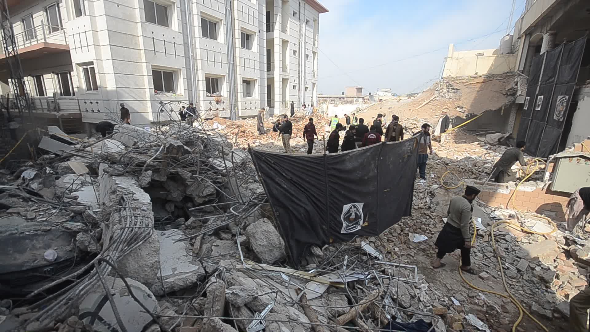 Police secure area of suicide bomb blast at a mosque that killed 100 people