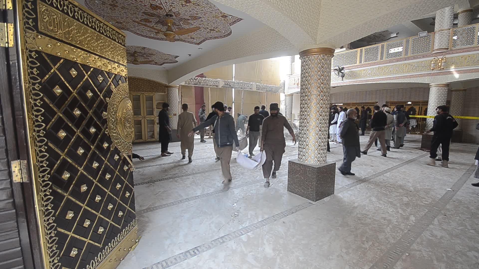 Police secure area of suicide bomb blast at a mosque that killed 100 people