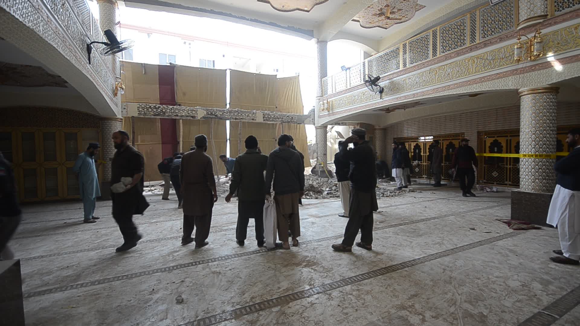 Police secure area of suicide bomb blast at a mosque that killed 100 people