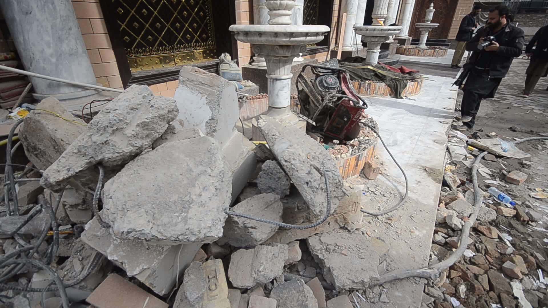 Police survey the scene of suicide blast at the mosque in Peshawar
