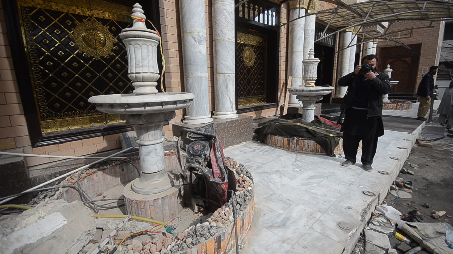 Police survey the scene of suicide blast at the mosque in Peshawar
