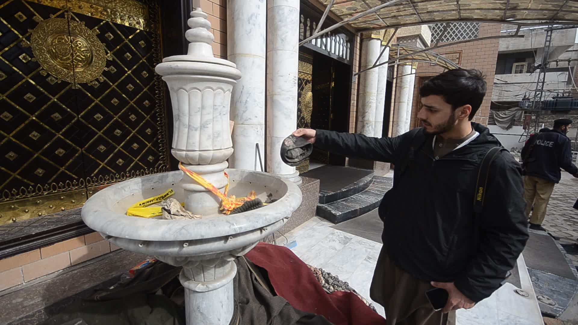 Police survey the scene of suicide blast at the mosque in Peshawar

