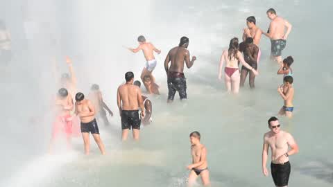 People bathe in the fountain of the Trocadero in Paris to escape the heat wave