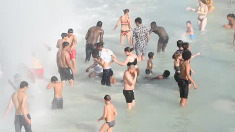 People bathe in the fountain of the Trocadero in Paris to escape the heat wave