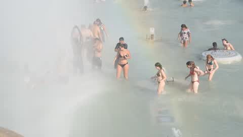 People bathe in the fountain of the Trocadero in Paris to escape the heat wave