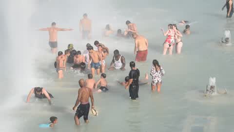 People bathe in the fountain of the Trocadero in Paris to escape the heat wave