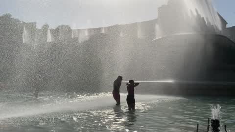 People bathe in the fountain of the Trocadero in Paris to escape the heat wave