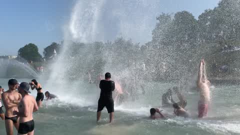 People bathe in the fountain of the Trocadero in Paris to escape the heat wave