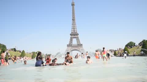 People bathe in the fountain of the Trocadero in Paris to escape the heat wave