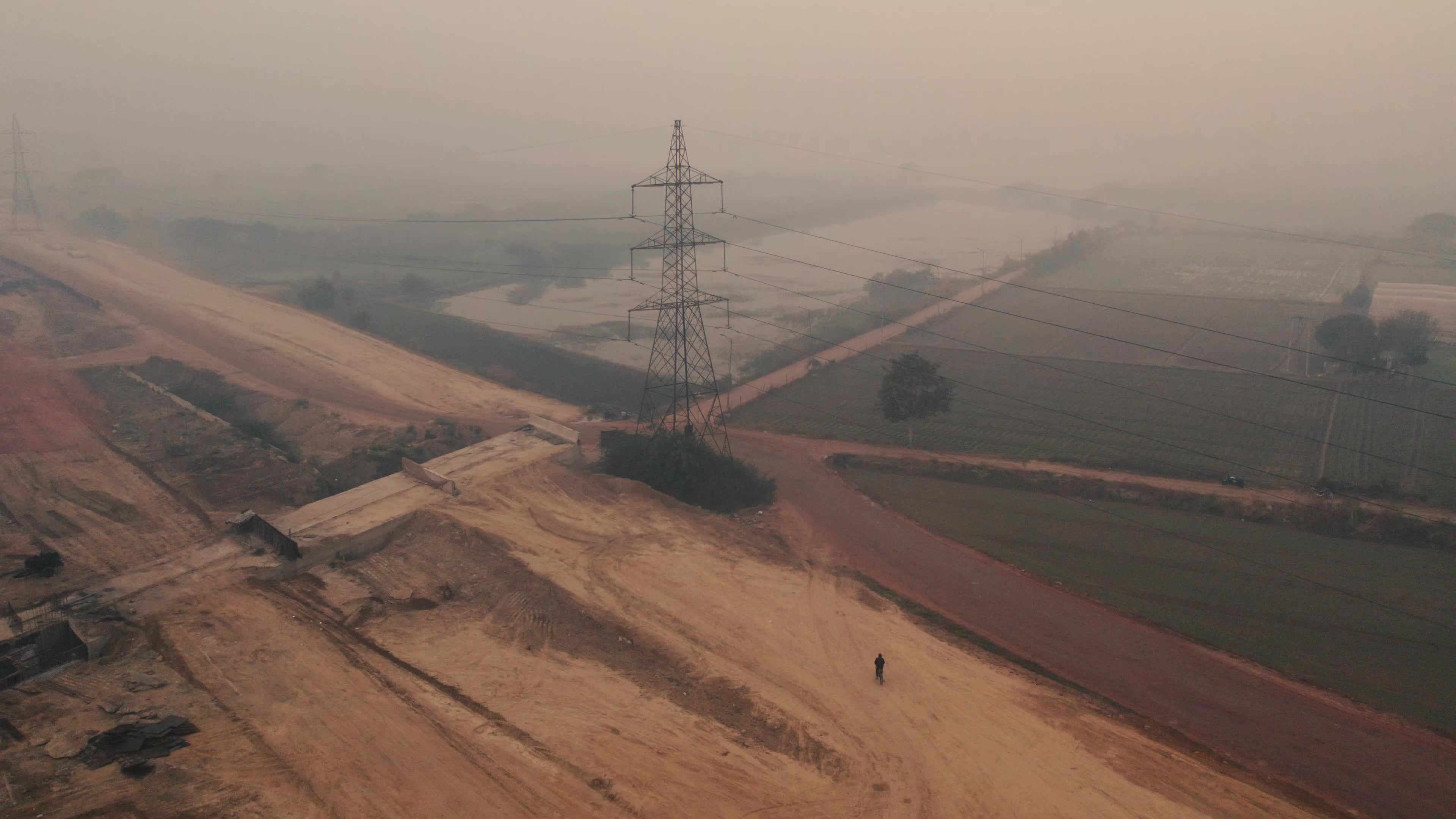 Aerial View of Electric Pylon next to an under-construction highway near the outskirt of New Delhi, India