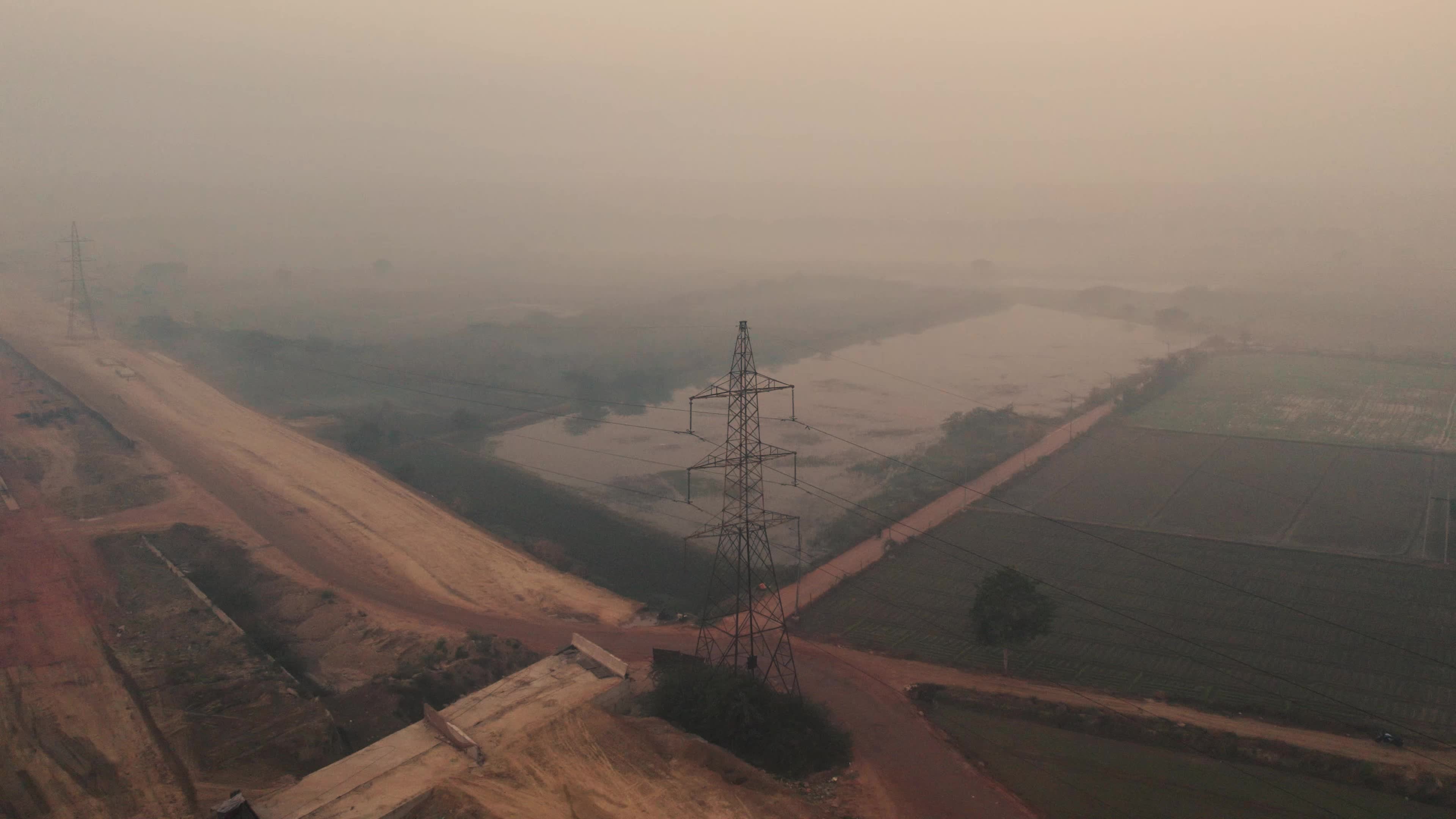 Aerial View of Electric Pylon next to an under-construction highway near the outskirt of New Delhi, India