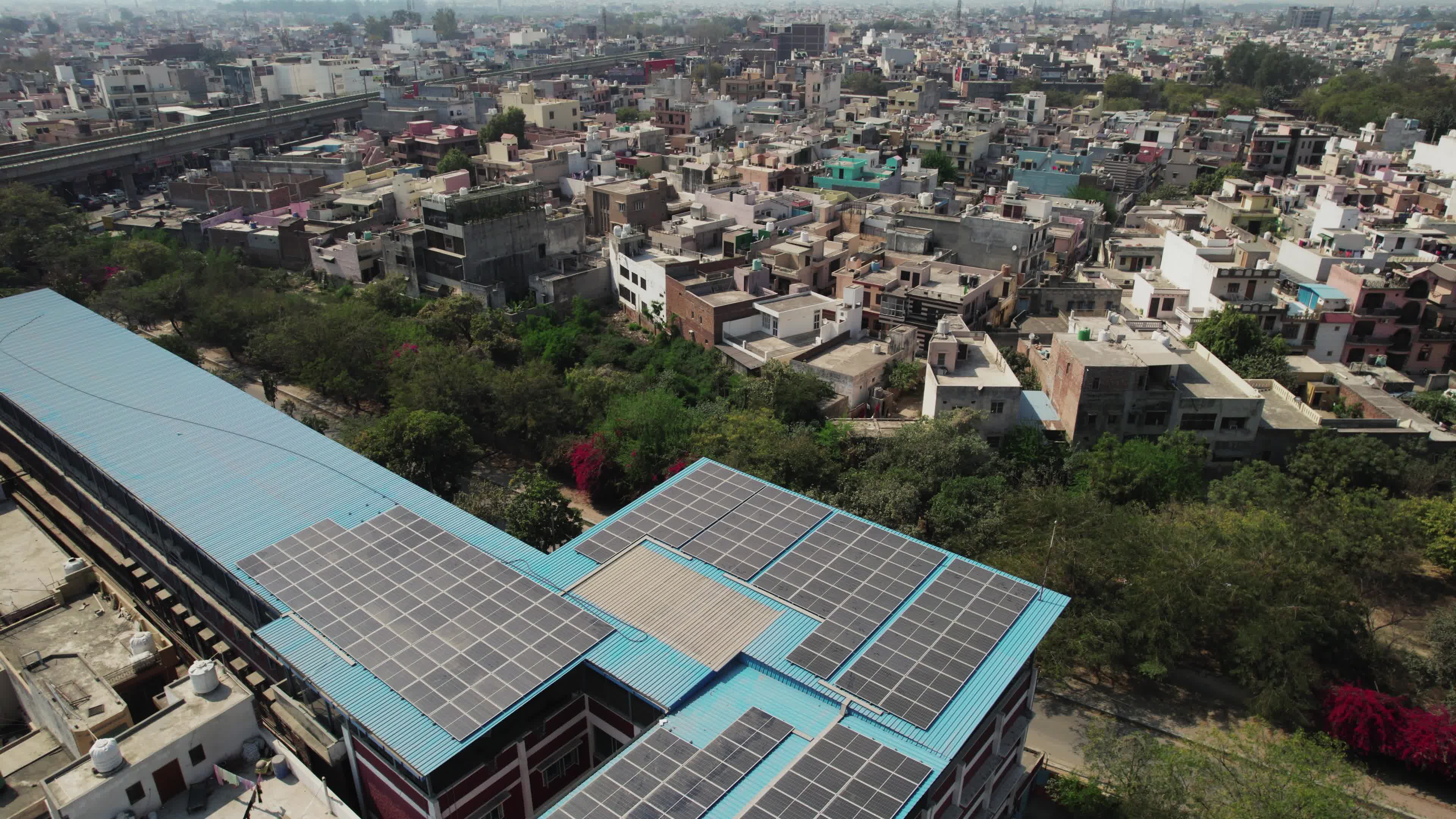 4K Aerial overpopulated View of Industrial & Residential Estate in Bahadurgarh City with elevated Metro train tracks, Harayana, India - stock video