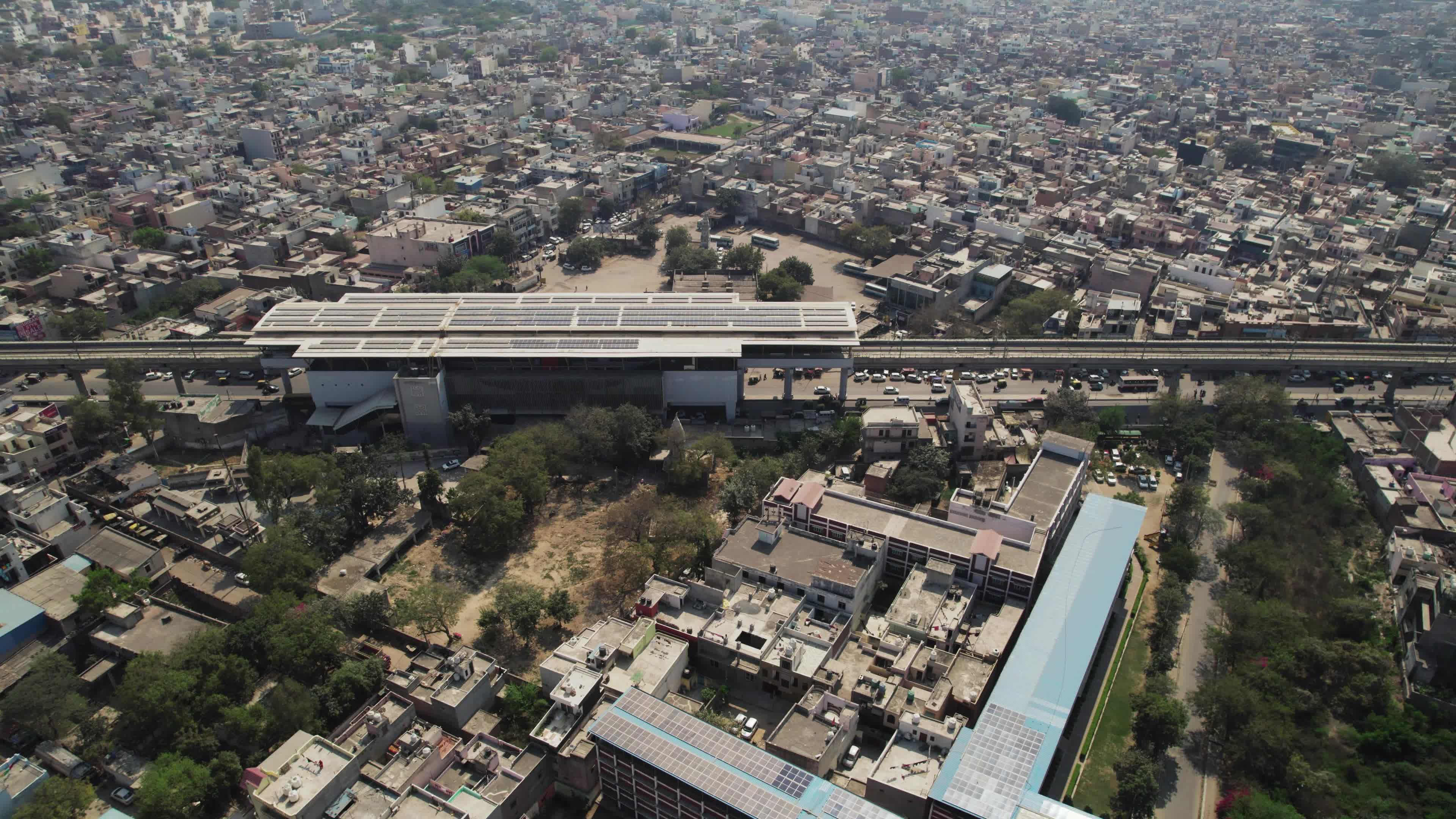 4K Aerial overpopulated View of Industrial & Residential Estate in Bahadurgarh City with elevated Metro train tracks, Harayana, India - stock video