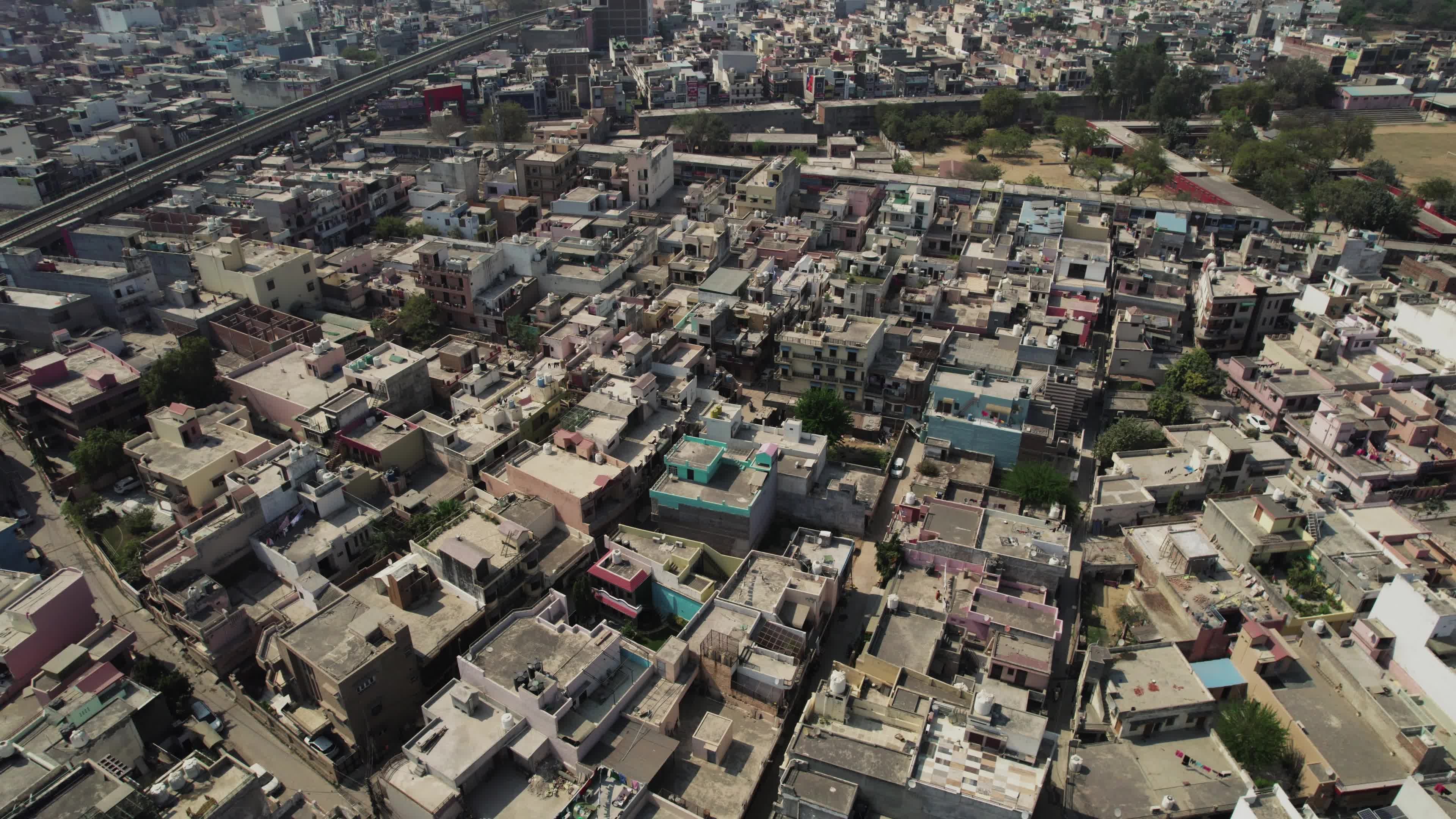 4K Aerial overpopulated View of Industrial & Residential Estate in Bahadurgarh City with elevated Metro train tracks, Harayana, India - stock video