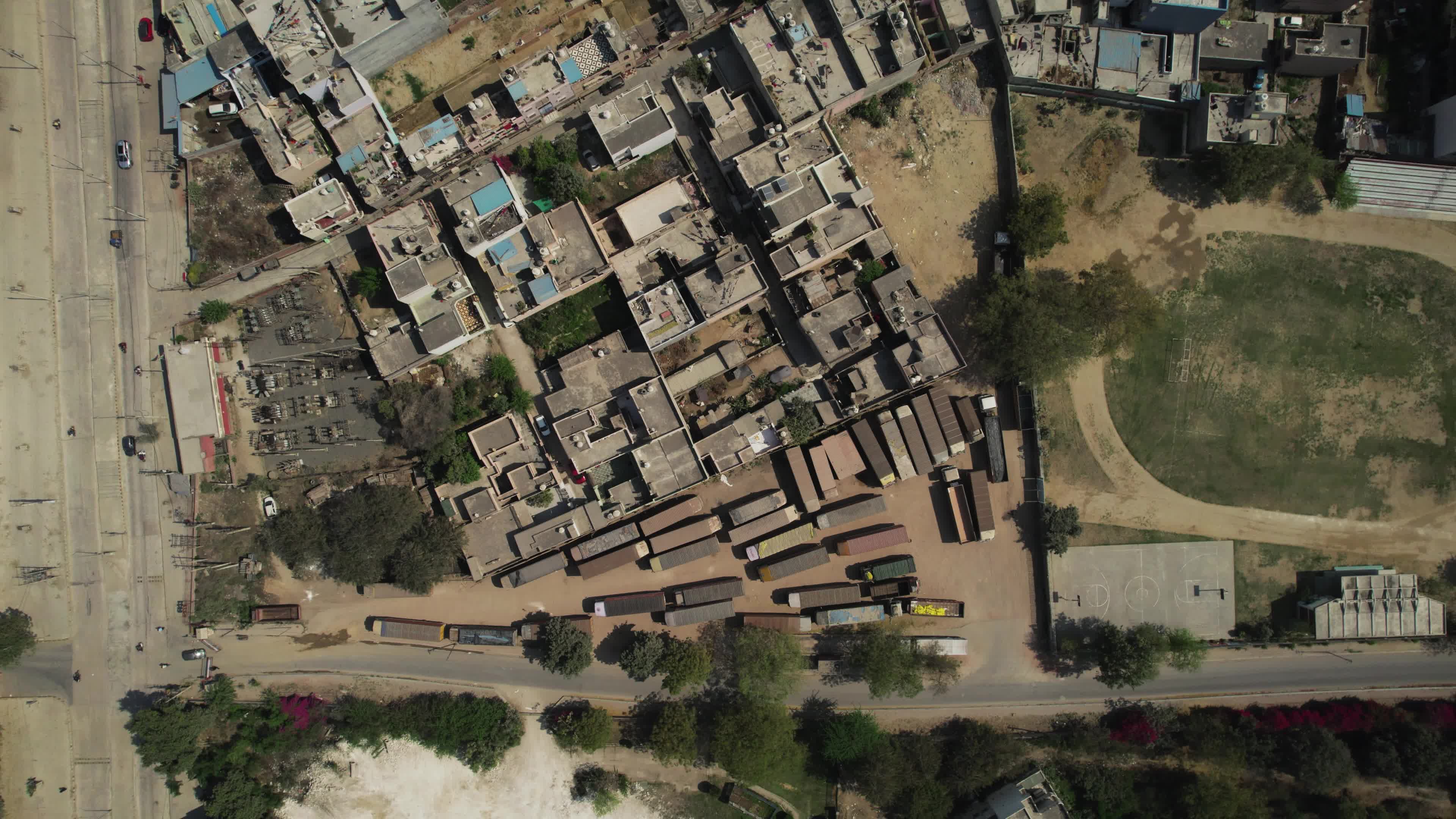 4K Aerial overpopulated View of Industrial & Residential Estate in Bahadurgarh City with elevated Metro train tracks and solar panels installed on the roof of the Metro Station, Harayana, India - stock video