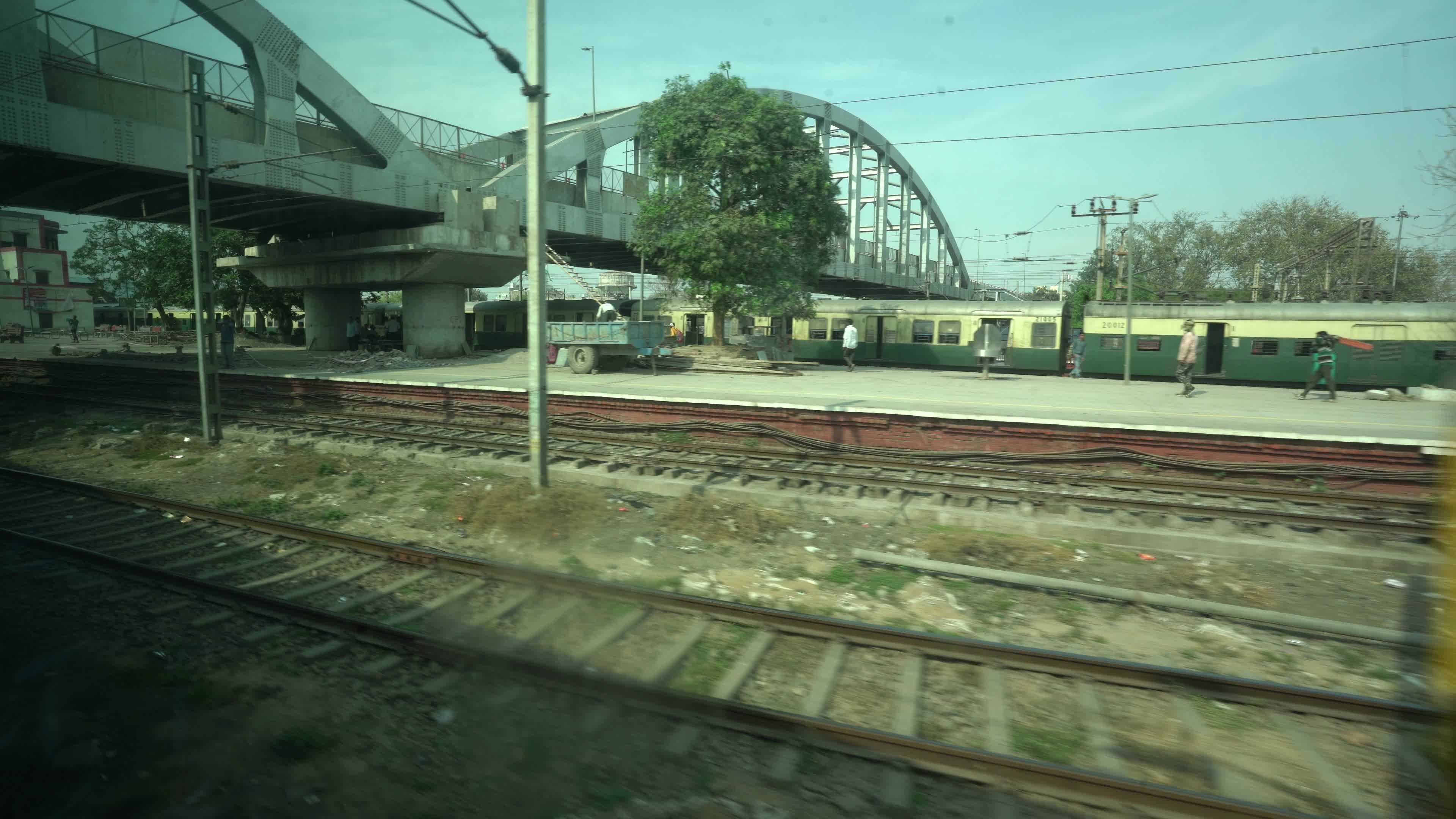 Views outside the window of a moving passenger train of Indian Railways in India, approaching the Ghaziabad Junction which is a major Railway junction in Northern India