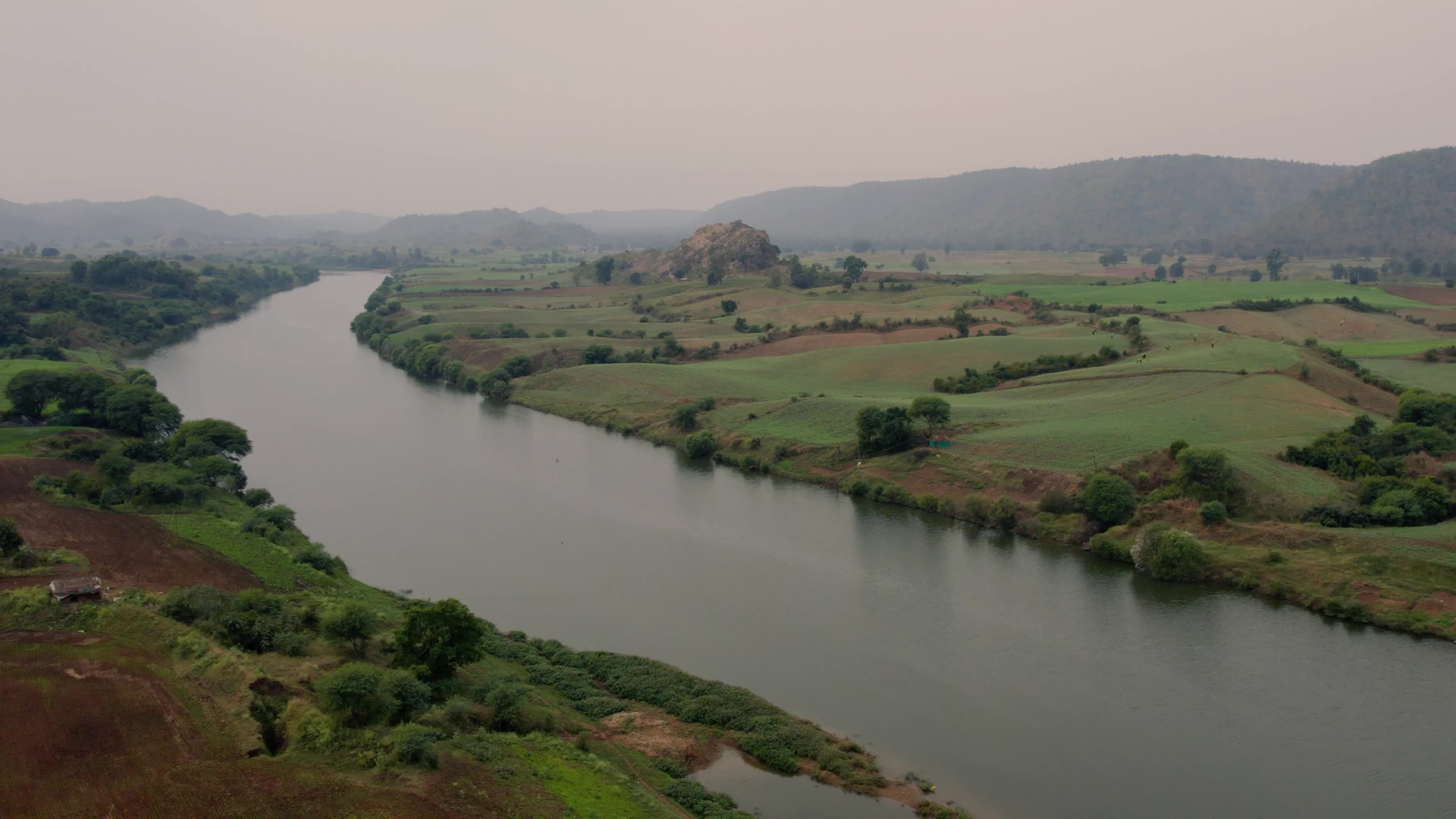 Beautiful drone view of a River surrounded by mountains and fields in the Indian state of Chhattisgarh