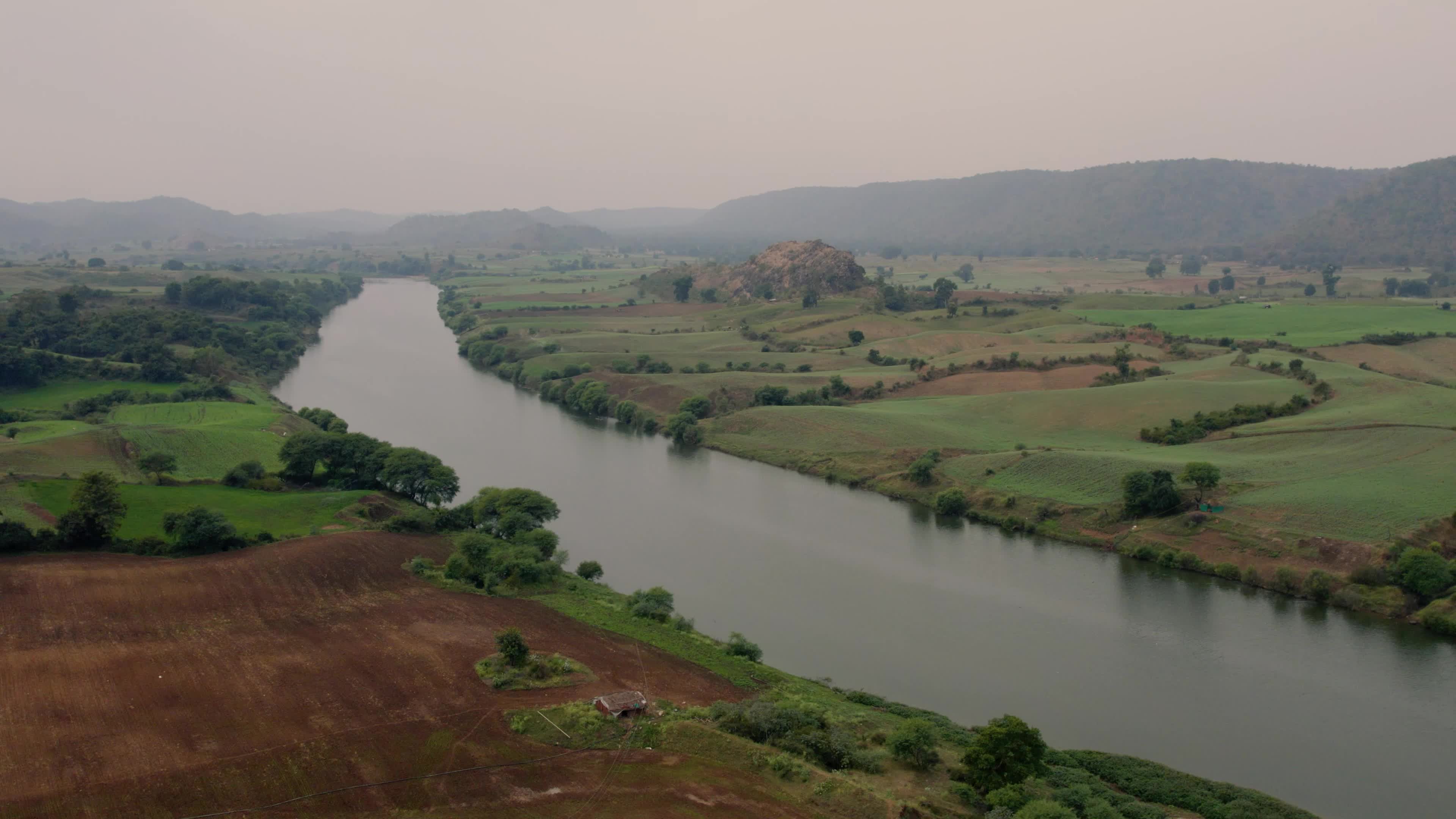 Beautiful drone view of a River surrounded by mountains and fields in the Indian state of Chhattisgarh